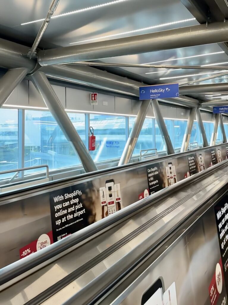 Covered moving walkway with HelloSky signs at Rome Fiumicino Airport