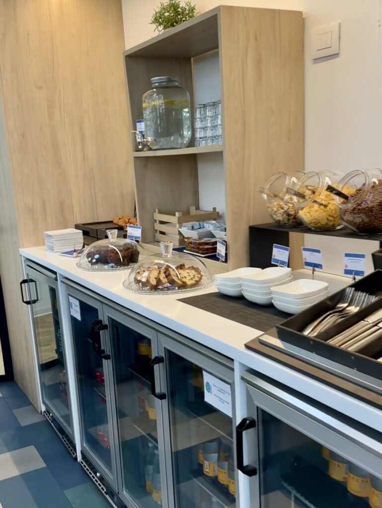 HelloSky lounge buffet with cereals, cakes, water and refrigerated drinks.