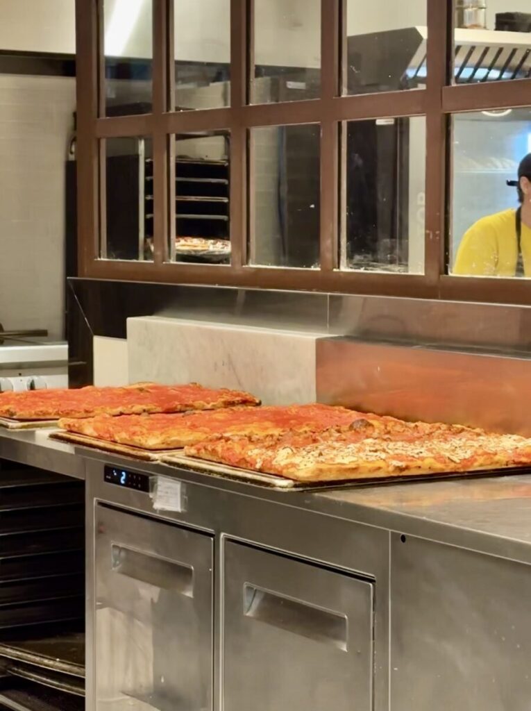 Rectangular pizzas displayed at a food counter in Rome Fiumicino Airport.